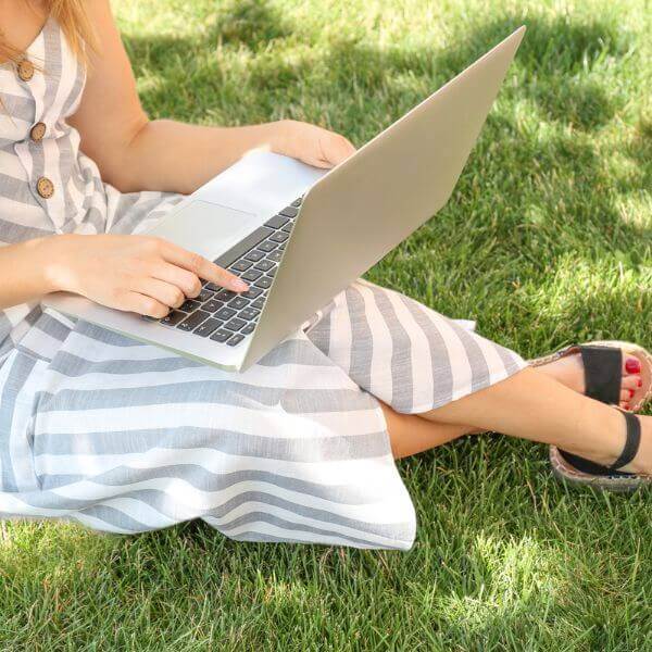 Frau mit Laptop im Gras